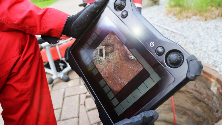 Person using a sewer camera to inspect the sewer line