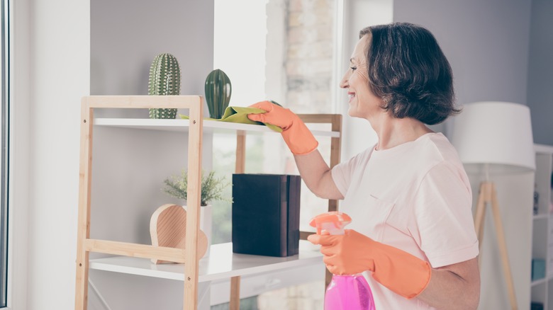senior citizen dusting shelf