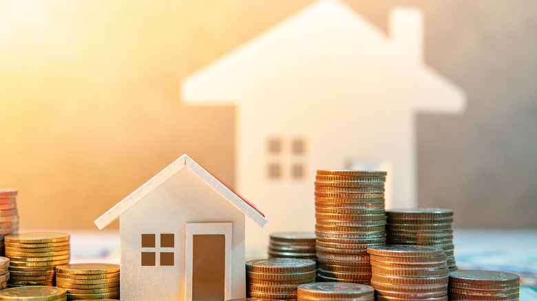 Illustration of a house with coins stacked beside it