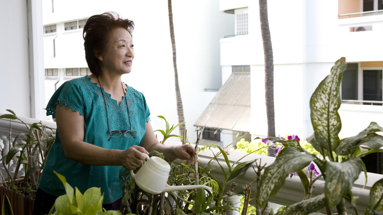 smiling woman using watering can