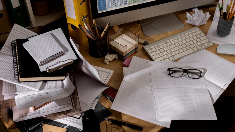 Cluttered desk littered with papers
