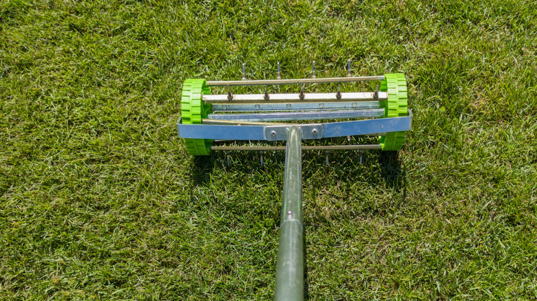 Someone using an aerator on lawn