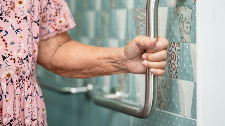 older adult holding a grab bar