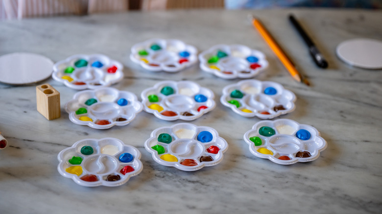 Colorful paints on several plastic paint palettes