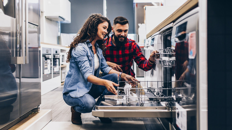 couple buying large appliance dishwasher