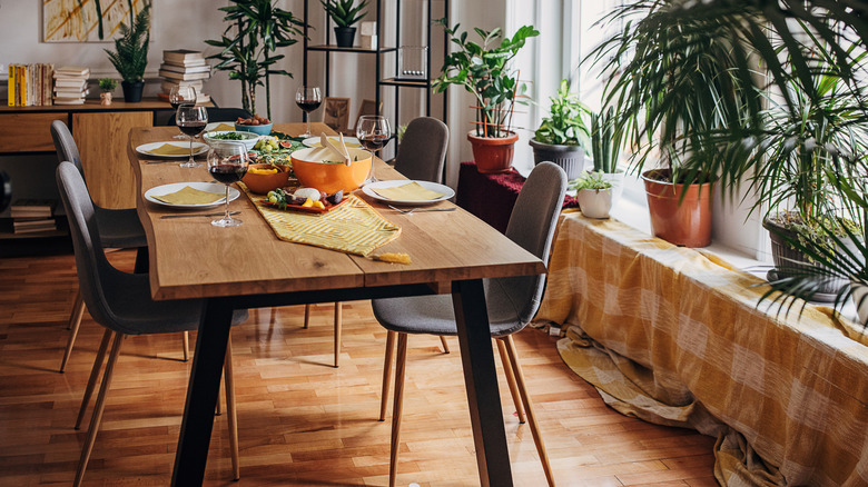 A modern wood dining table set for dinner.