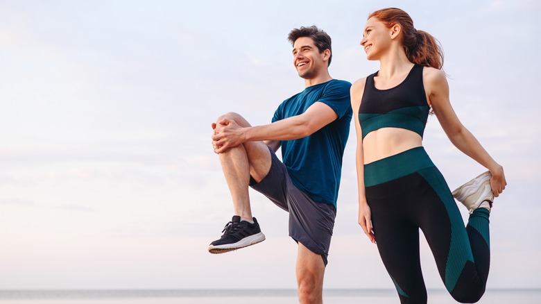 man and woman stretching