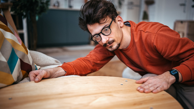 A person inspecting a round table top