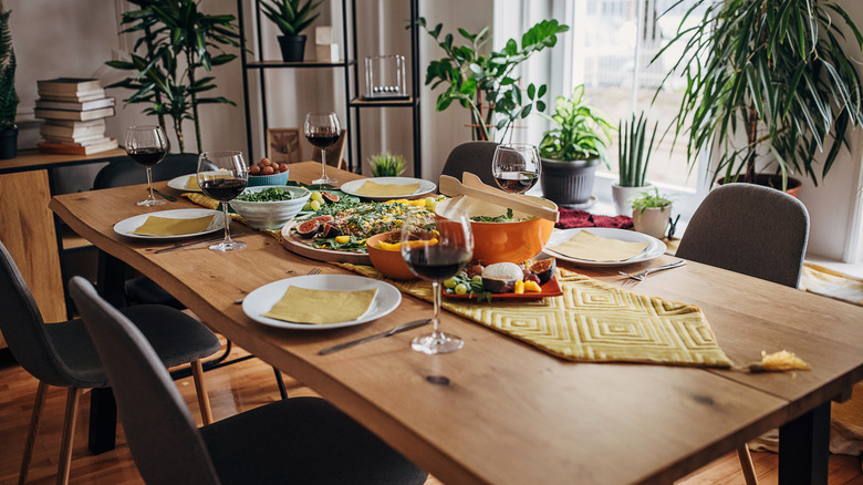A dining table set with a meal and wine served on top
