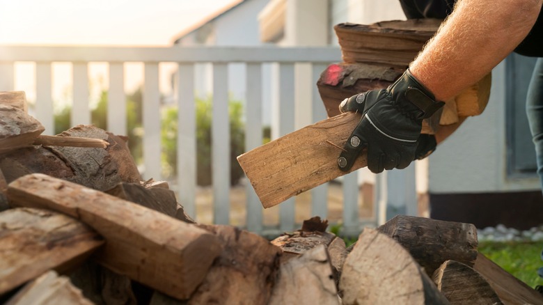 Man dropping firewood into pile