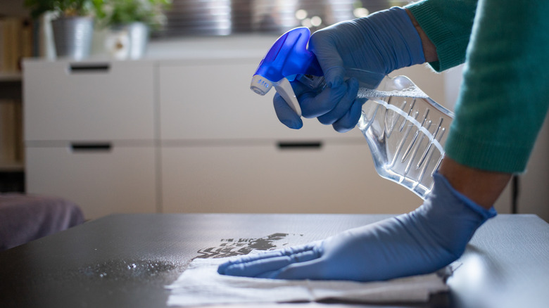 person cleaning with spray bottle