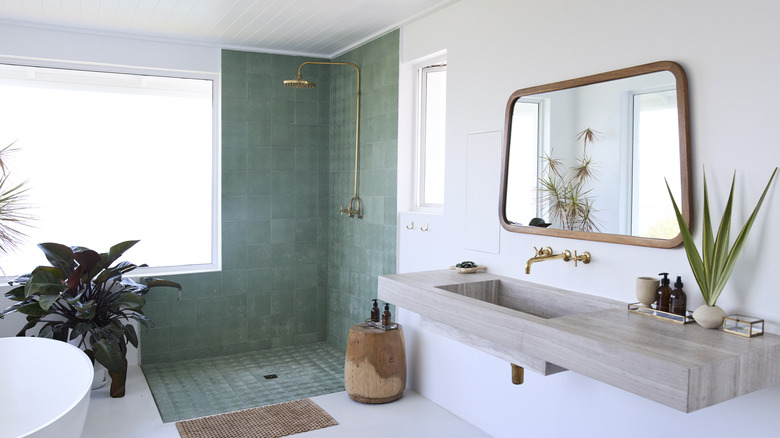Interior of bathroom in modern home with green tile and gold fixtures