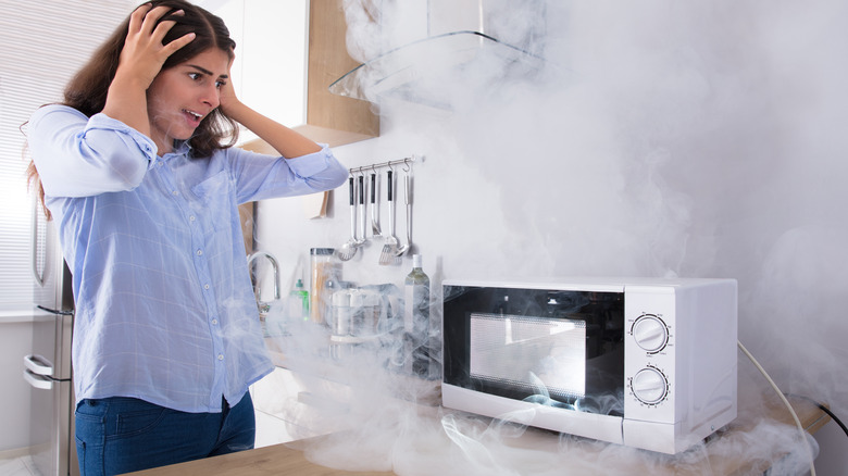 Woman with smoking microwave