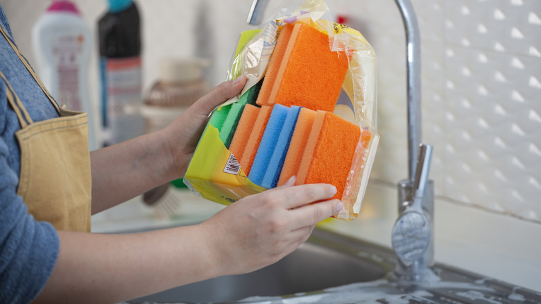 Person opening pack of sponges
