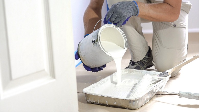 Person pouring white paint