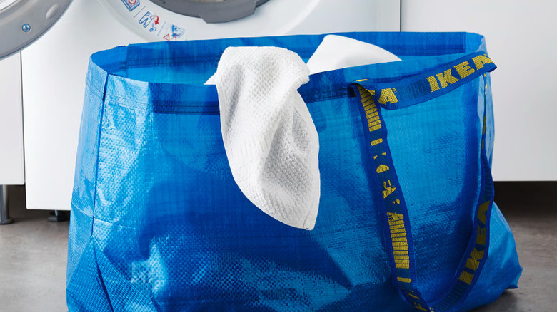 IKEA FRAKTA bag holding laundry in front of a washer