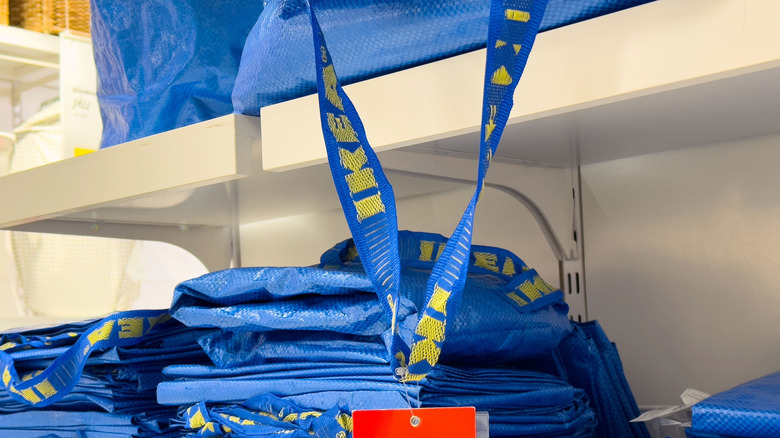 Stack of folded IKEA FRAKTA bags on a shelf