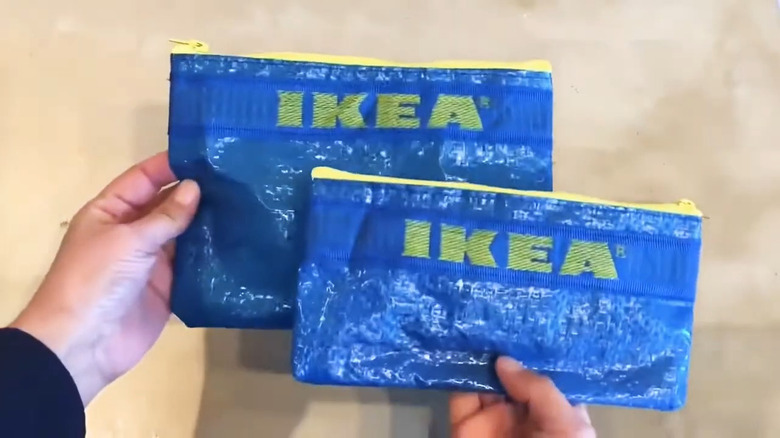 Person holding two different sized pencil cases made from IKEA bags