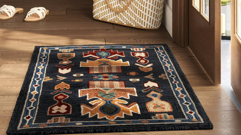 Threshold's global wool accent rug is styled on a wood floor with other natural materials.