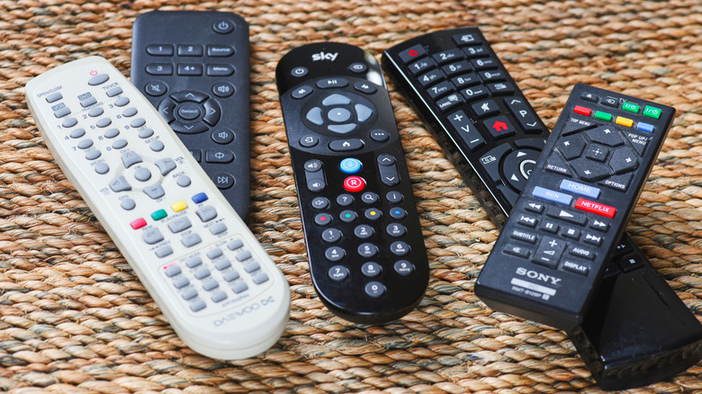 Several TV remotes on a table.