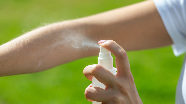 woman spraying insect repellent