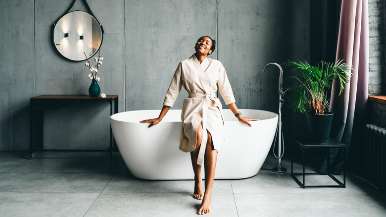 Woman smiling while leaning on bathrub