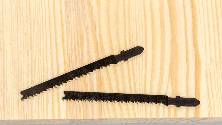 Two jigsaw blades on wood