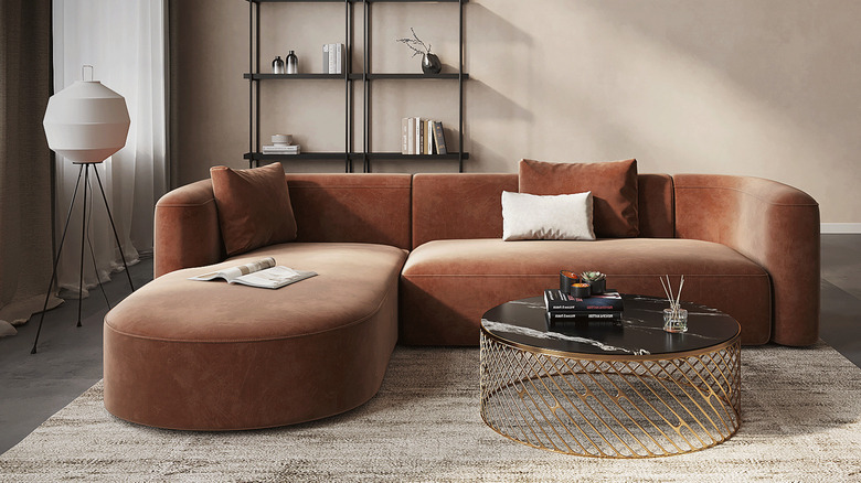 A rust-colored velvet modern sofa in a living room