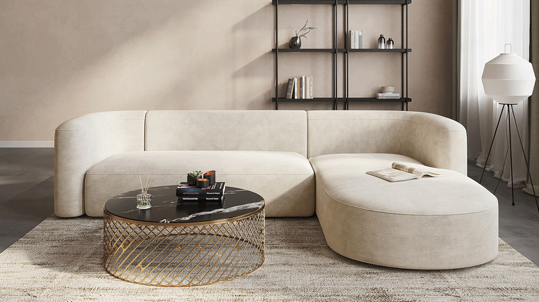 A cream-colored modern sofa in a neutral living room