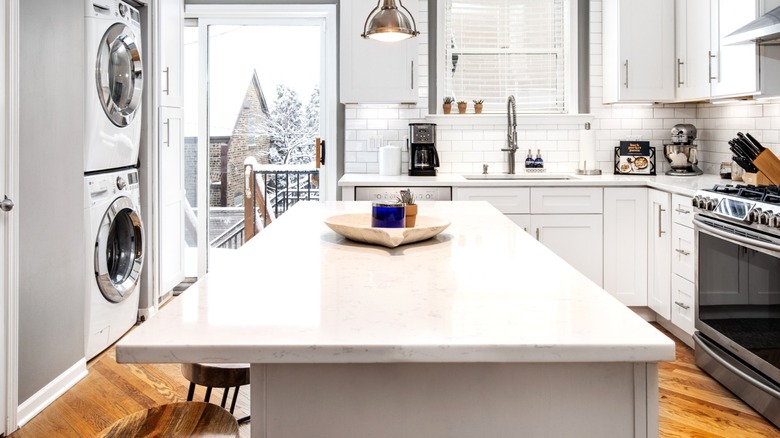 Kitchen island in front of door leading to snowy outdoor landscape