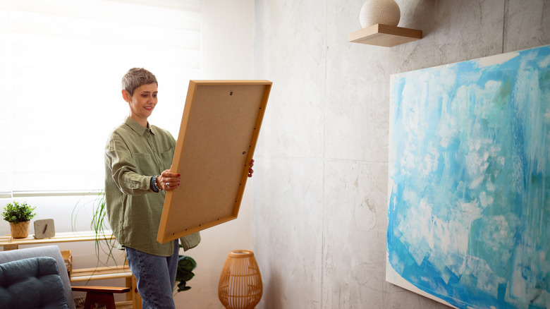 Woman holding framed artwork
