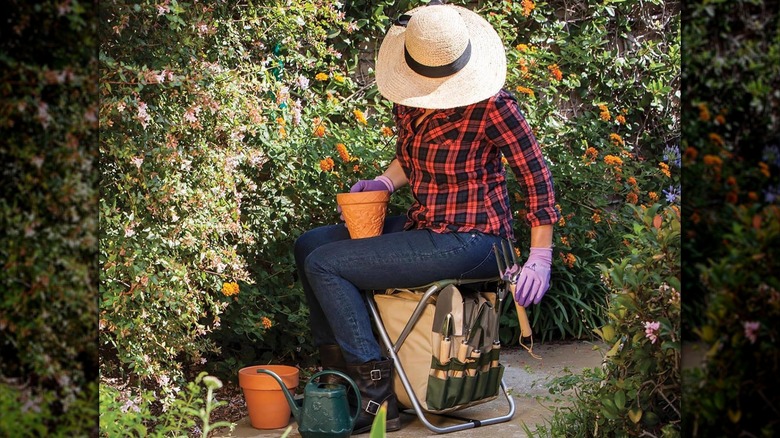 Woman sitting on gardening bench working in the yard