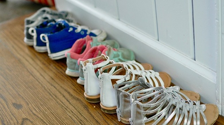Children's shoes lined up in a hallway.