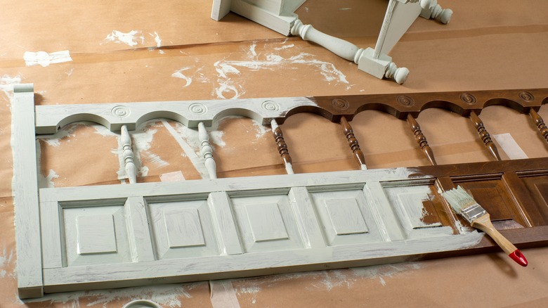 An old wooden headboard, half painted white