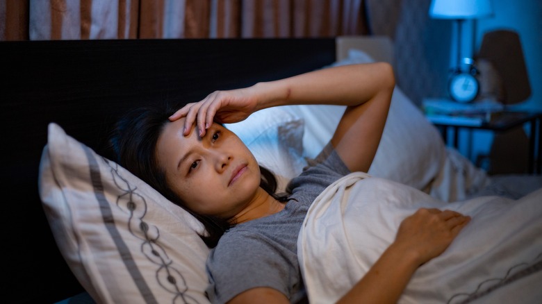 Woman lying in bed unable to sleep