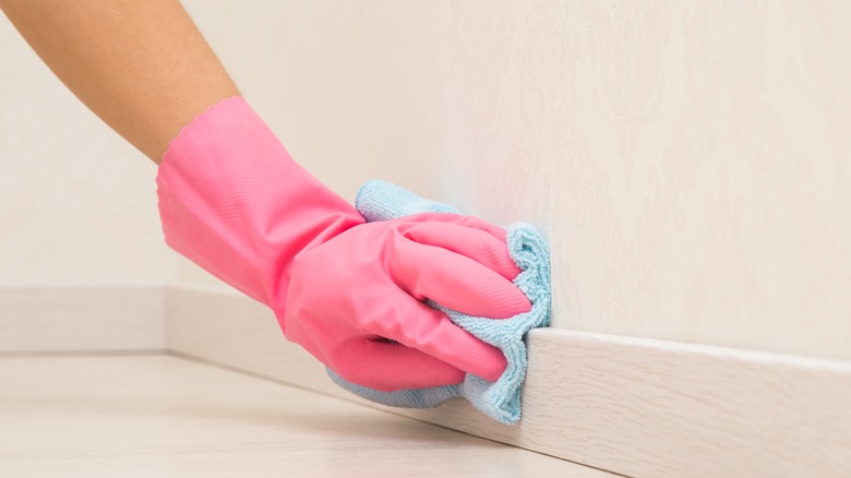 Person scrubbing baseboard