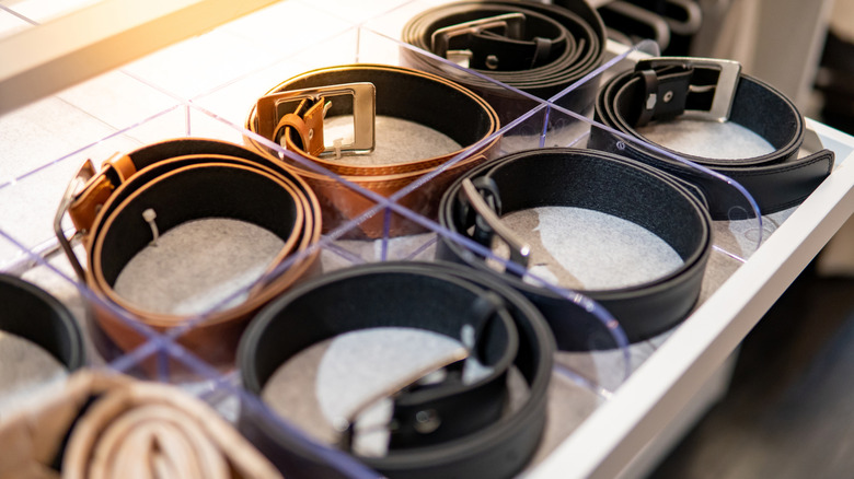 Belts coiled up in a drawer organizer