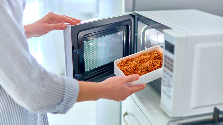 Putting food in a microwave 