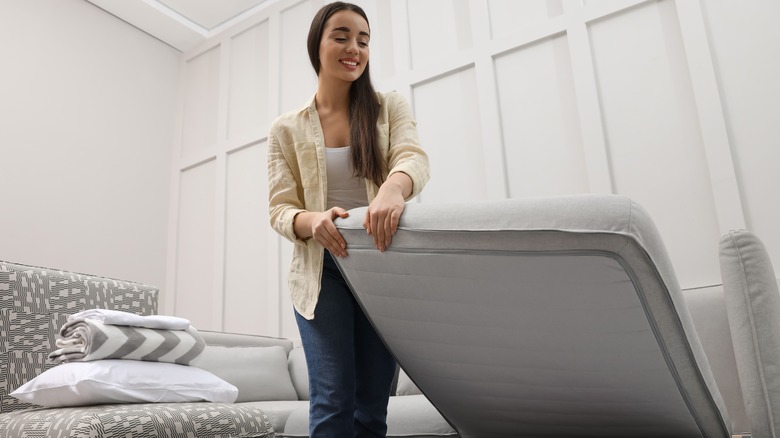 Woman setting up sleeper sofa bed