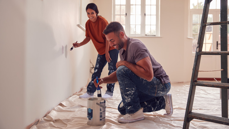 couple painting wall white