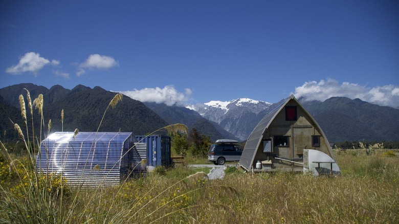 house, greenhouse, and vehicle against mountain