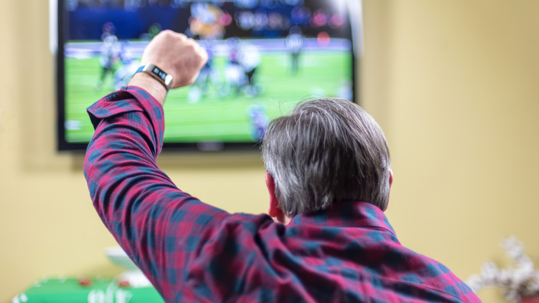 man pumping fist watching the Superbowl