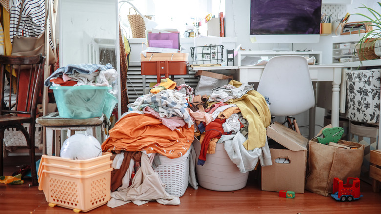 room cluttered with toys, clothes, messy desk