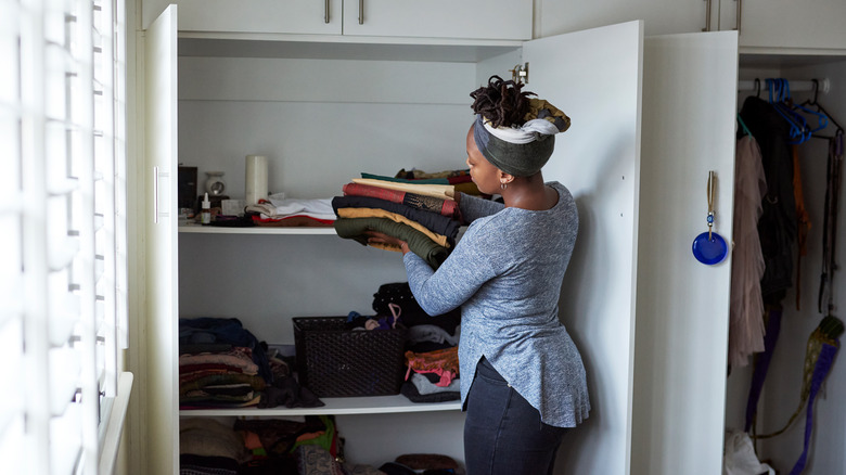 woman putting clothes in her closet