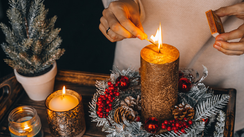 person lighting a Christmas candle