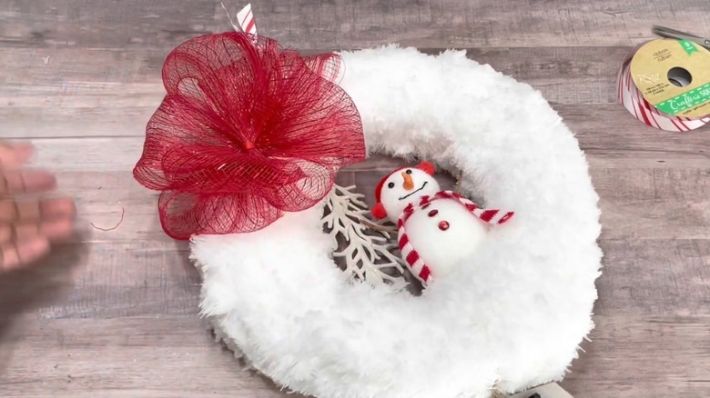 Homemade snow-covered wreath with snowman and red bow
