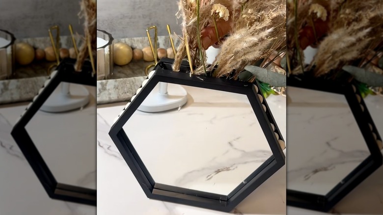 DIY vase made with beads and hexagon mirror holding dry flowers