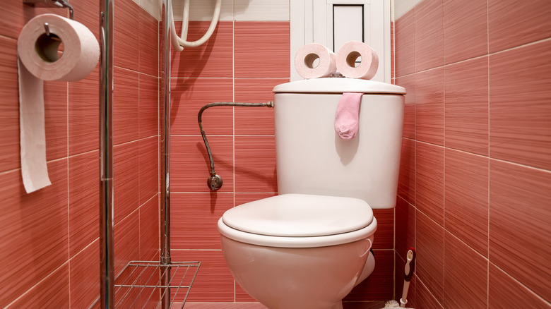 toilet in red-tiled bathroom