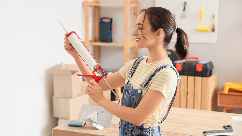 woman holding up sealant gun