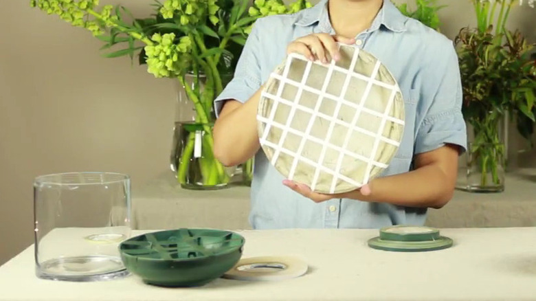 Woman holding a vase with a taped grid
